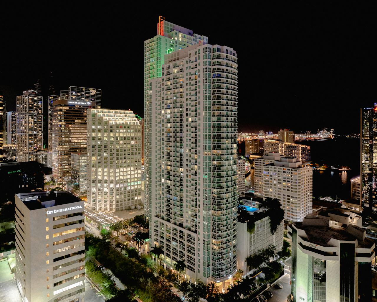 A vibrant city skyline at night featuring illuminated skyscrapers against a dark sky.
